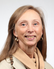 Headshot of a woman wearing a tan sweater.